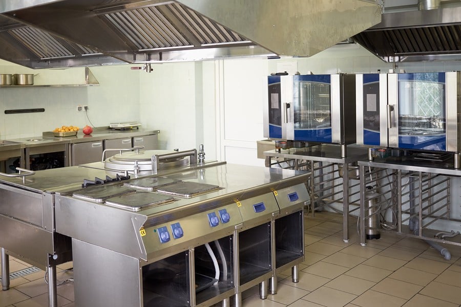 kitchen room with stoves, sinks and refrigerators in restaurant.
